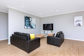 A living room with a black sofa and a television.