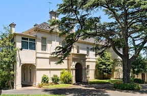 a mansion with a large tree in front of it