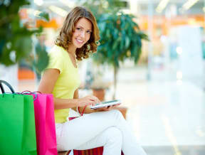 a woman sitting on a suitcase holding a tablet