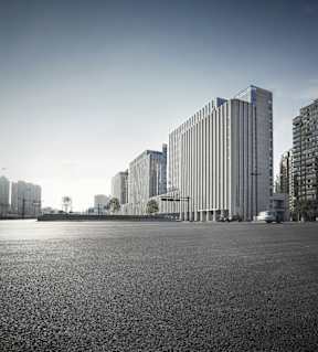 a black and white photo of a large empty square with tall buildings in the background