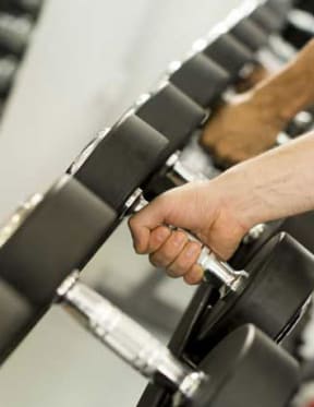 a hand is holding onto a bar in a gym
