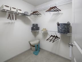 a walk in closet with hangers and a basket