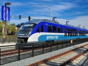 a blue and white train traveling down train tracks