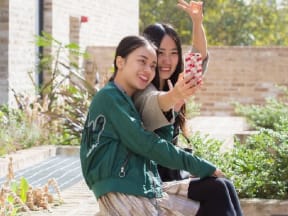 two friends taking a picture on the steps of a building