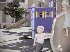 a little boy and girl playing on a slide