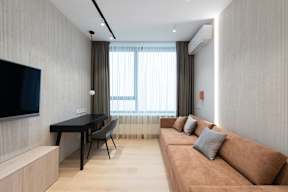 A living room with a brown couch, a black table, and a television.