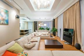 A modern living room with a white sofa and a television.