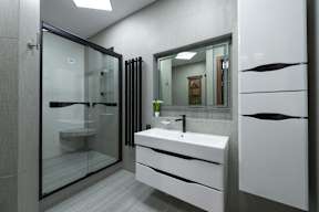 A modern bathroom with a white sink and a glass shower.