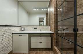 A bathroom with a white countertop and a white sink.