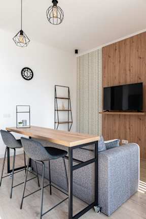 A modern dining area with a wooden table and grey chairs.