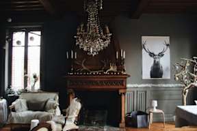 A living room with a fireplace and a chandelier.