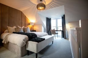 a bedroom with a bed and a desk in a hotel room