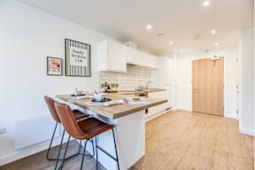 A kitchen with a table and chairs and a sign that says Sunday Breakfast Club.