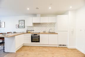 A kitchen with white cabinets and a wooden counter top.