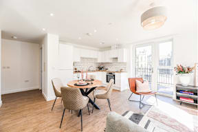 A modern kitchen with a dining table and chairs.
