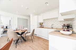 A modern kitchen with a dining table and chairs.