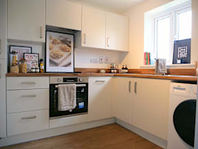 A modern kitchen with white cabinets and a wooden countertop.