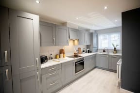 a kitchen with gray cabinets and a stove and a sink