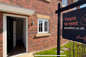 A sign that says "Yours to rent" is in front of a brick building.