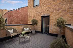A small balcony with a table and two chairs.