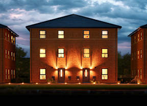 A large brick building with lights on the front and windows on the second floor.