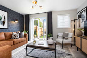 A living room with a brown couch, a white chair, and a coffee table.