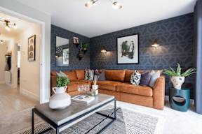 A living room with a brown couch and a grey coffee table.