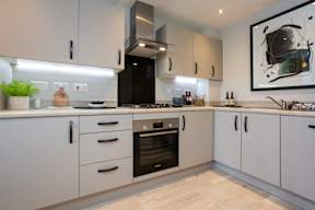 A modern kitchen with white cabinets and a black oven.
