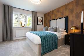 A bedroom with a large bed and a window with curtains.