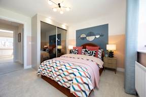 A bedroom with a large bed and a ceiling fan.