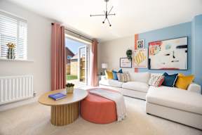 A living room with a white couch, a round table, and a painting on the wall.