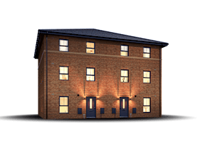 A three-story brick building with a black roof and lit windows.