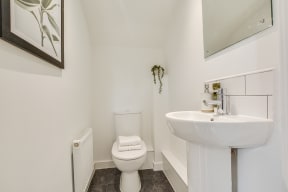 a white bathroom with a sink and toilet and a mirror