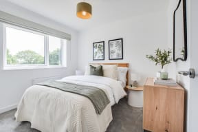 a bedroom with a bed and a large window