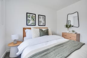 a bedroom with a bed and two pictures on the wall