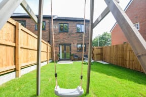 a swing in a backyard with a house