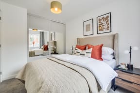 a bedroom with a large bed and a mirror