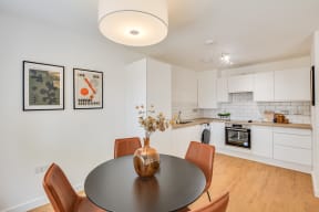 a kitchen and dining room with white cabinets and a table and chairs