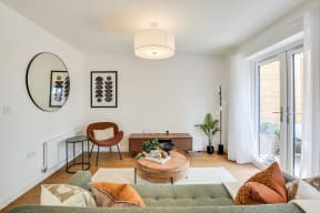 a living room with a couch and a chair and a window