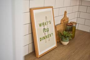 A wooden framed sign that says "What's for Dinner?" is on a table.
