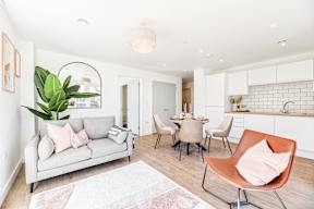 A living room with a grey couch and a white rug.