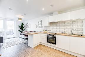 A kitchen with white cabinets and a wooden floor.