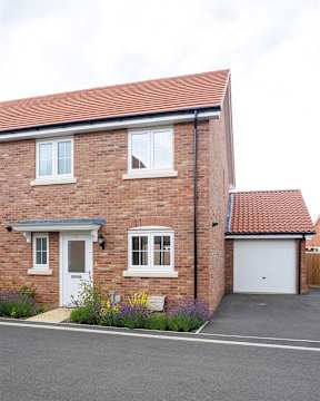 A brick house with a white door and windows.