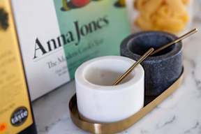 A white cup with a spoon in it is on a tray.