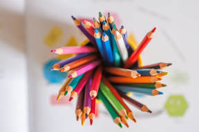 A bunch of colored pencils are arranged in a star shape.