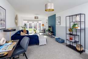 A living room with a blue couch and a grey chair.