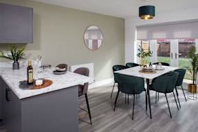 A kitchen with a marble countertop and a dining table with chairs.