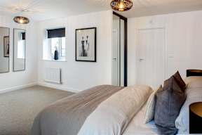 A bedroom with a large bed and a ceiling light.