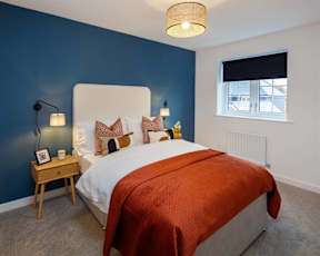 A bedroom with a bed, nightstand, and window.