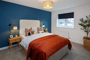 A bedroom with a large bed and a window.